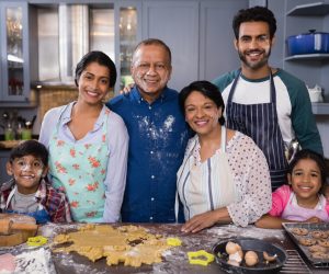 Portrait of smiling multi-generation family standing together in kitchen at home